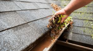 DIY enthusiast cleaning gutters with a ladder