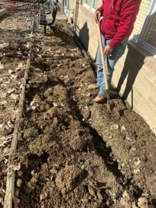 man digging soil for drainage system
