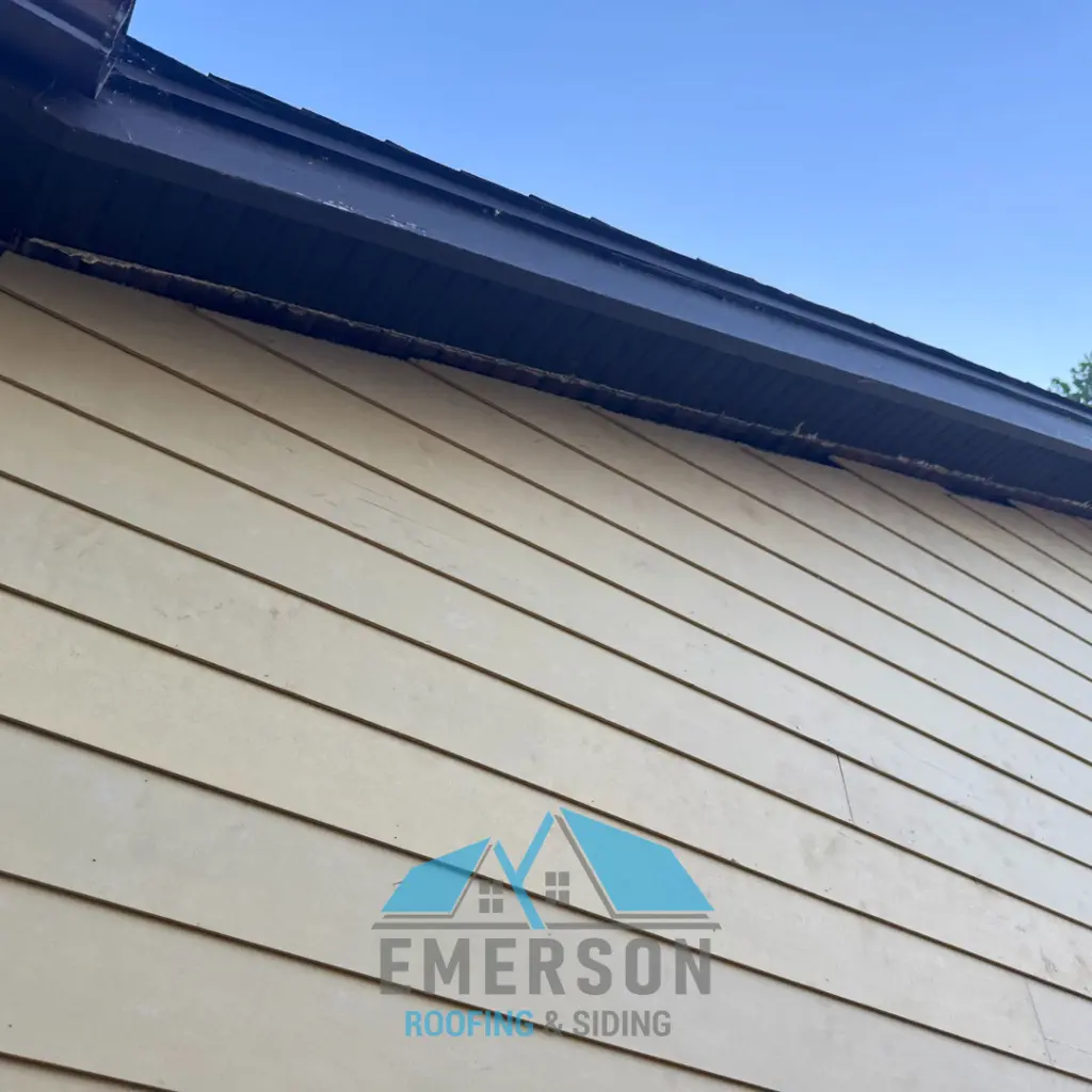 Beige lap siding beneath a home roofline and fascia