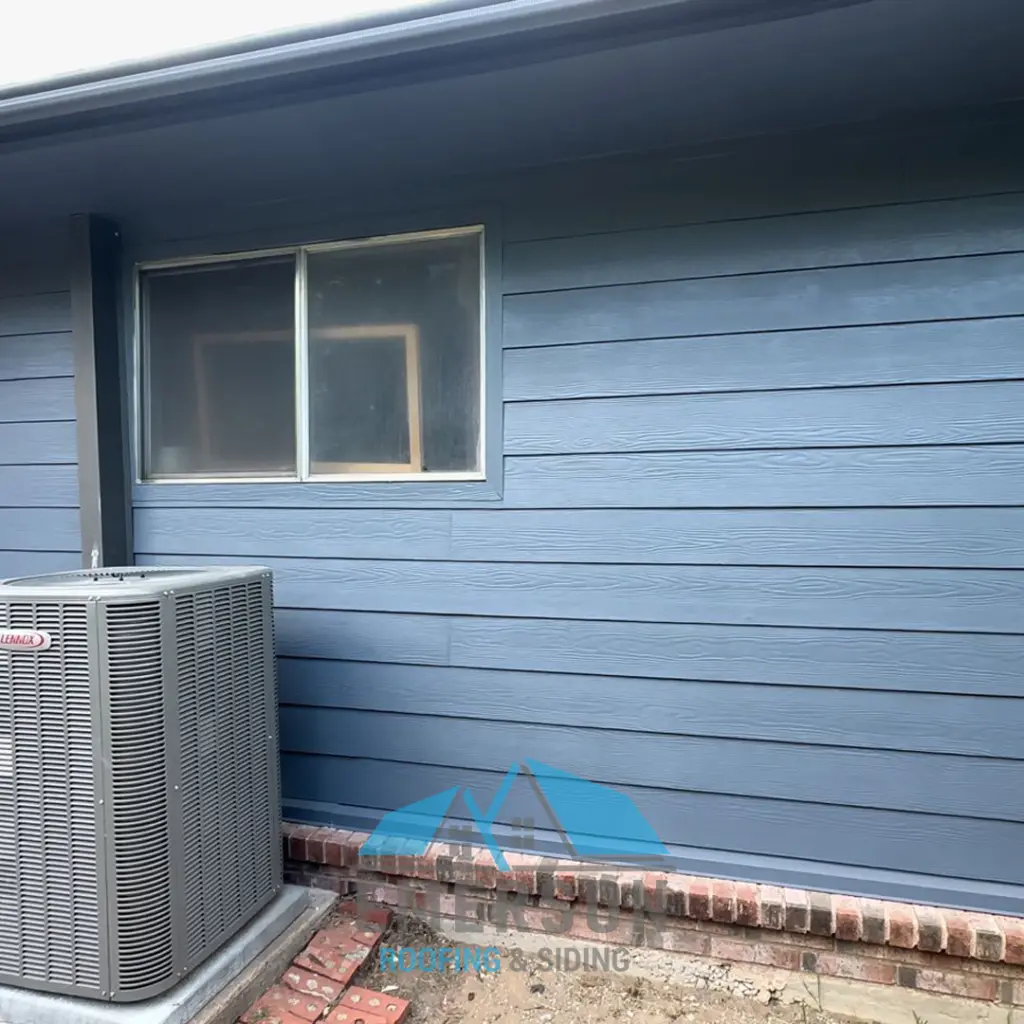 Blue horizontal siding on a residential exterior wall with a window