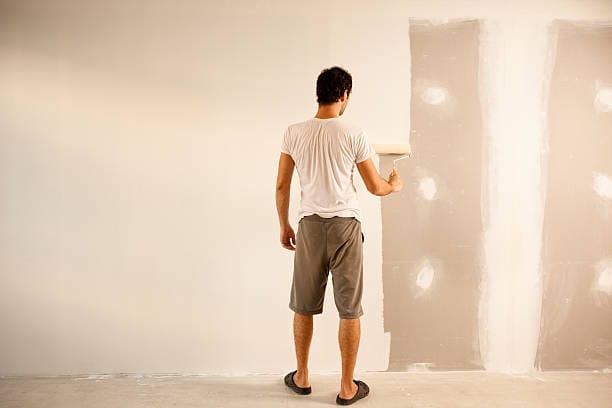 man painting on wall