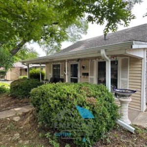 Residential Gutter and Downspout Inspection - Emerson Pro Services Existing gutters and downspout on a single-story home surrounded by mature trees and shrubs.